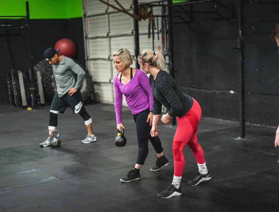 A coach guiding an athlete through movement coaching